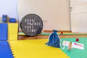Zidni sat s natpisom "Good things take time" i pribor za crtanje u sobi za vježbanje